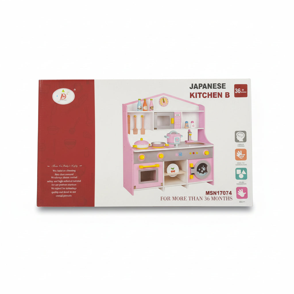 A boxed children's toy kitchen set photographed on a cardboard surface. The package is mostly white and red, with a large illustration of a pink play kitchen on the front.
